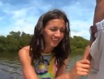 Ragazza in costume che scopa il suo ragazzo in barca sul fiume